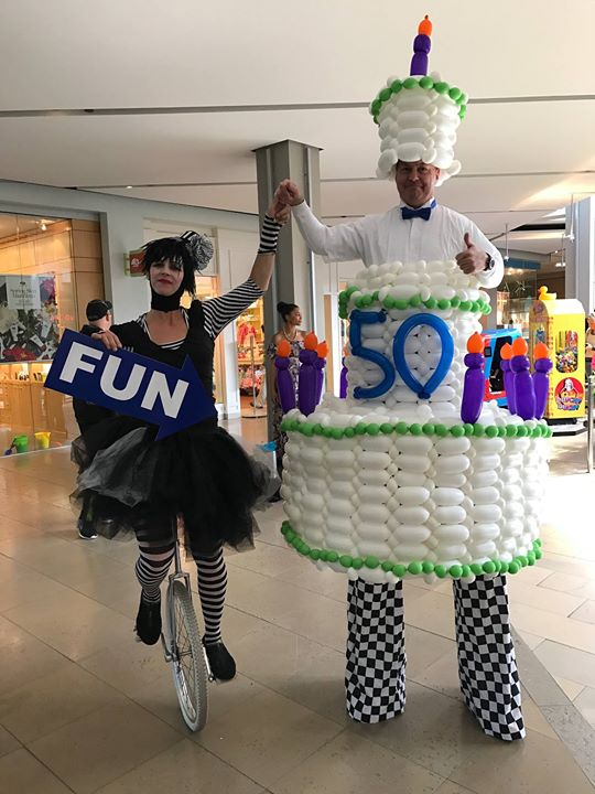 Paul made this awesome balloon cake & he’s wearing it on stilts, and Lisa…